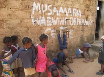 Musamaria-orphanage-kids-playing-in-front-of-brick-wall