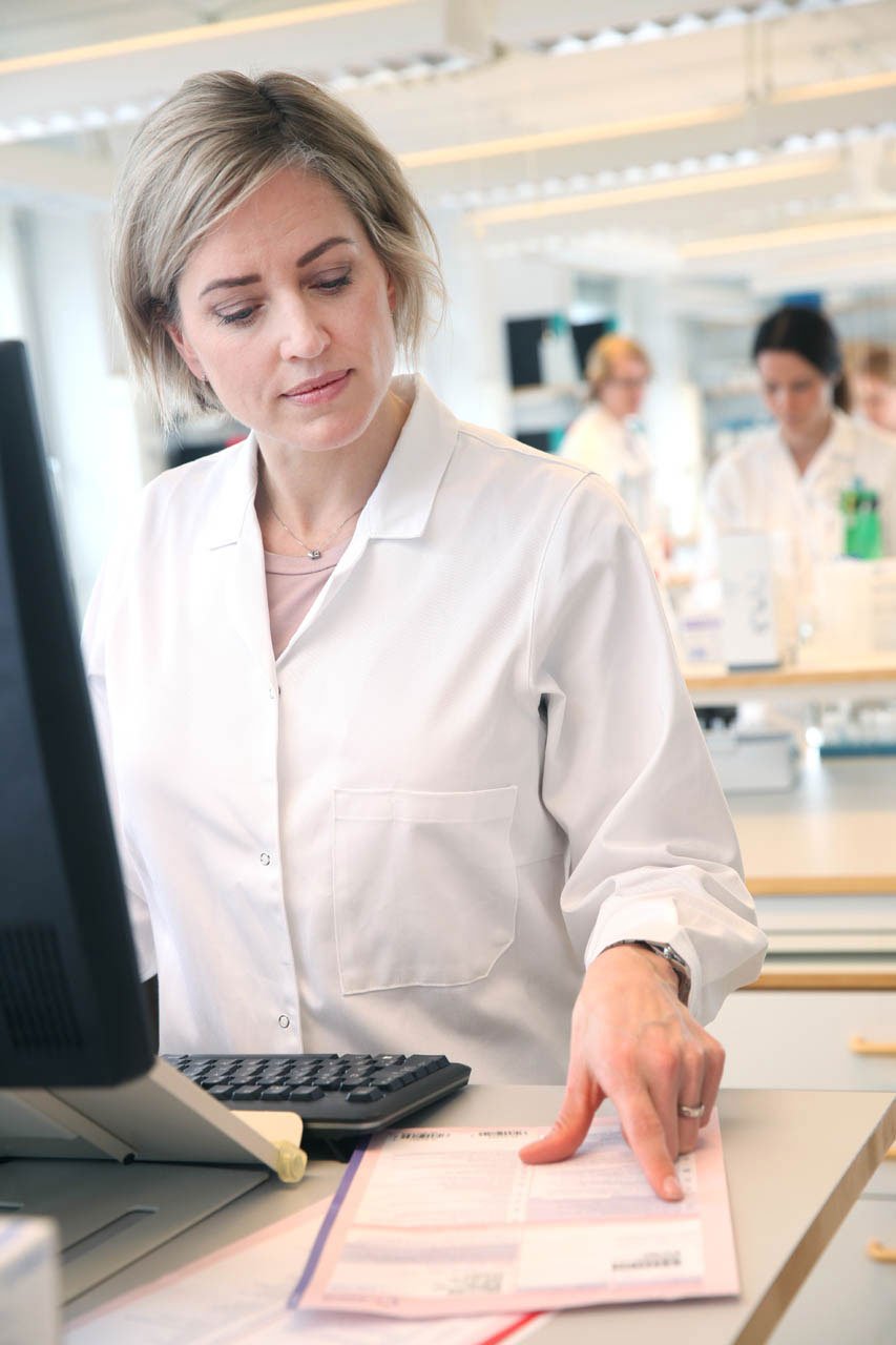 Svar-Life-Science-female-laboratory-technician-in-front-of-computer-reading-request-form-in-diagnostic-services-laboratory