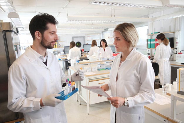 Svar-Life-Science-laboratory-technicians-holding-and-reviewing-samples-in-busy-diagnostic-services-laboratory